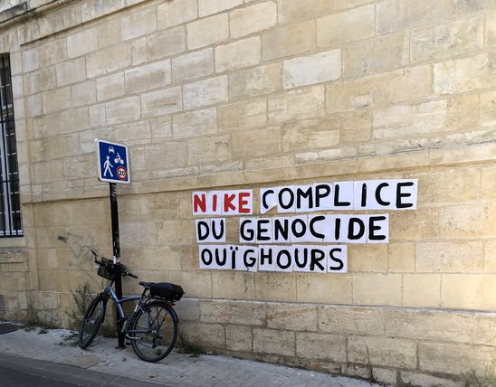 Collage sur un mur à Bordeaux dénonçant la politique de travail forcé utilisée par des marques internationales. (Crédit photo : Louise Bur-Palmieri)