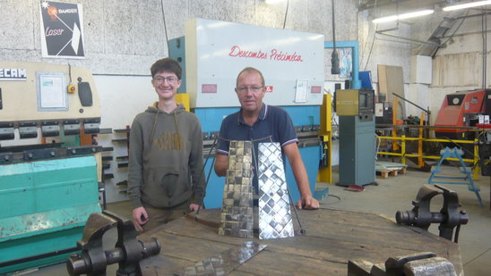 Alain Fer dans l'atelier métallerie du Lycée présente une robe sculptée en fer (Crédit photo : Justin Lenoël)