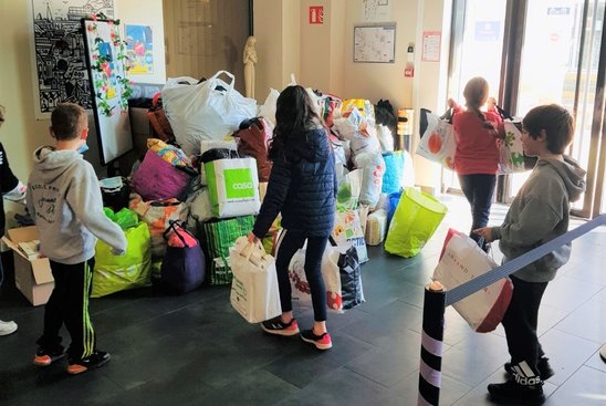 Les élèves de l'école Jeanne d'Arc apportent leurs dons. (Crédit photo : Julie Neveu)