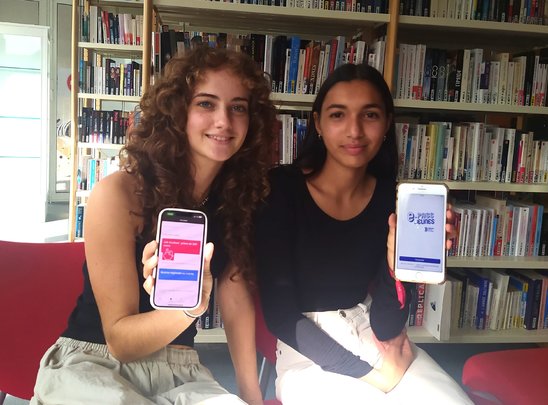 Charlotte (à gauche) et Sohalia consultant l'application e-Pass jeune. (Crédit photo : Suzanne Tessier)