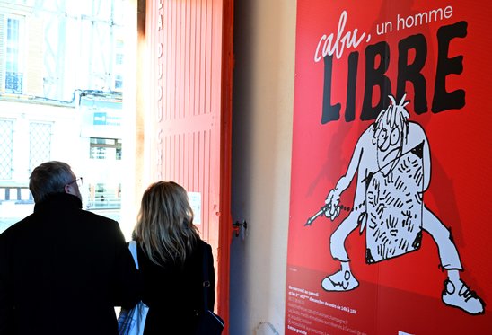 Des visiteurs devant une affiche de l'exposition \