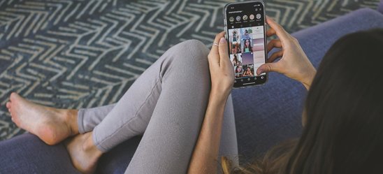 Femme sur un canapé avec un smartphone (Crédit photo : Pexels - Los Muertos Crew)