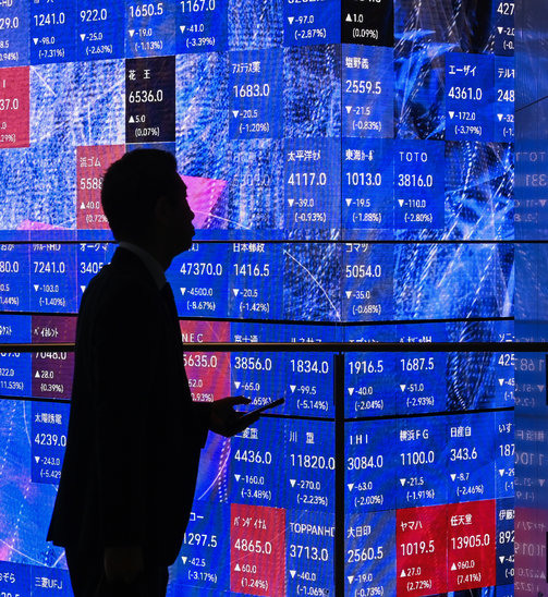 L'IA draine des investissements financiers énormes, comme ici à la bourse de Tokyo. (Crédit photo : AFP/Archives / GREG BAKER)