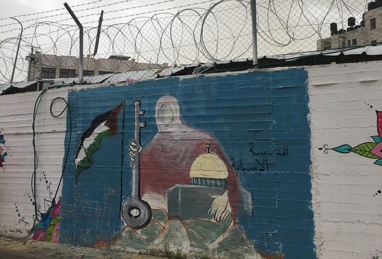 Peinture sur un mur barbelé à Ramallah en Cisjordanie représentant la mosquée et la clé de Jaffa, emblèmes palestiniens. (Crédit photo : A. Filatre)